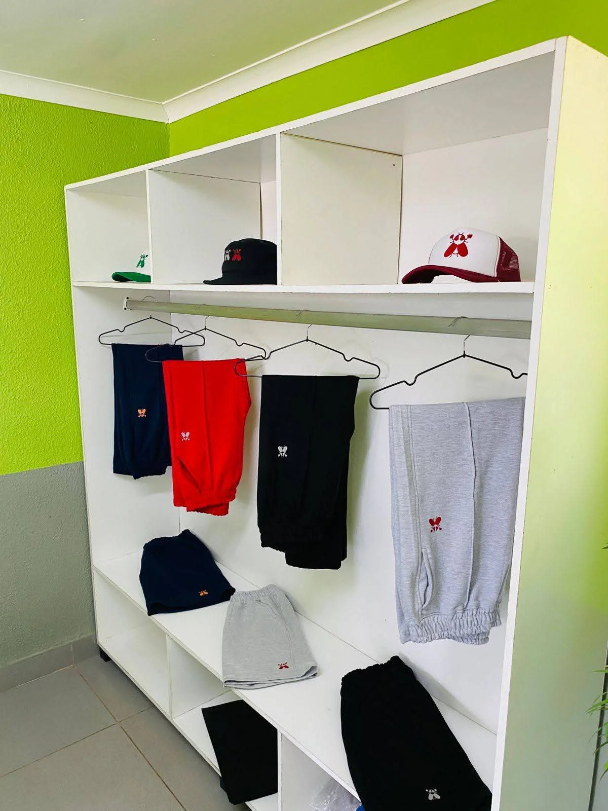 A SACXESS store display of folded and hanging bottoms and caps
